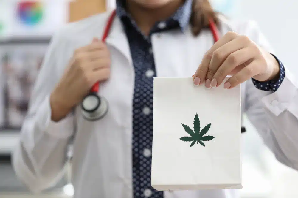 Doctor Holding White Paper Bag branded with Cannabis Leaf